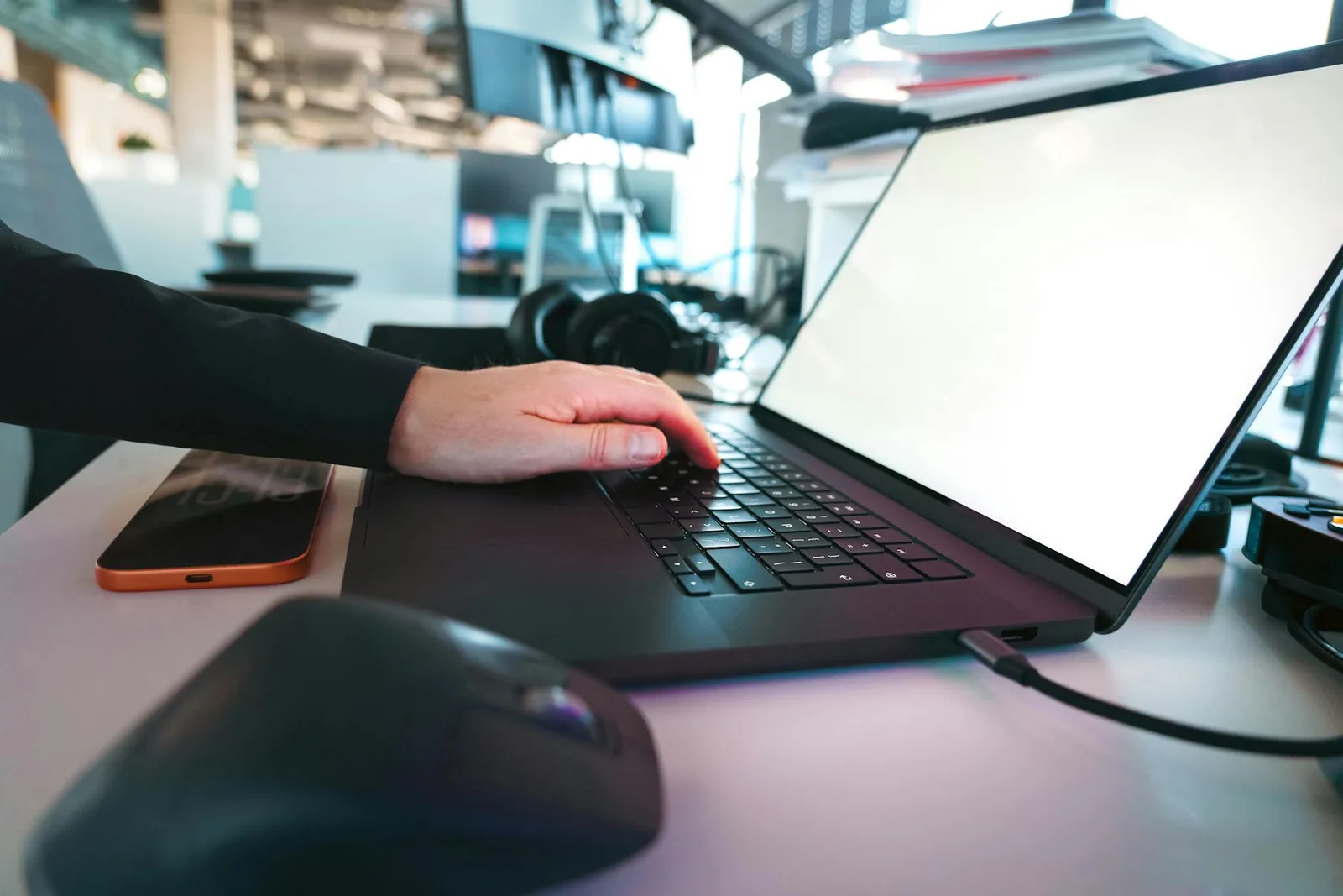 Moderni työpiste, jossa näkyy kannettava ja digitaalisia työkaluja