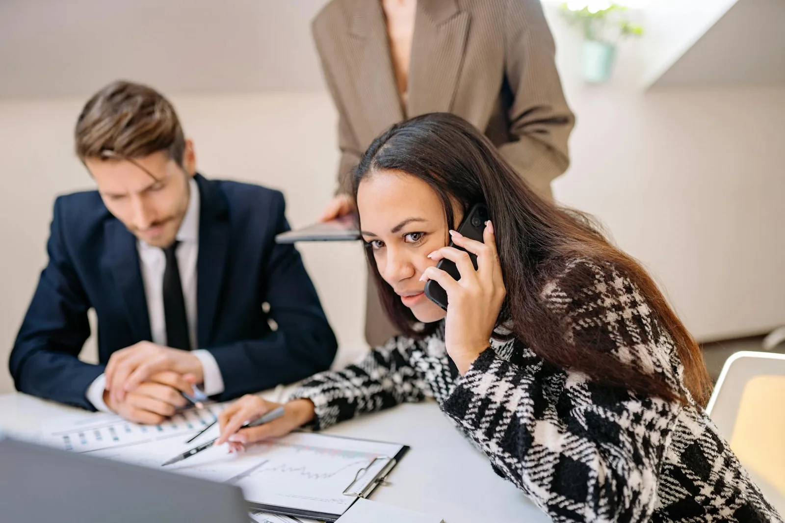 Tiimi suunnittelee puhelinvaihteen vaihtoa toimistopalaverissa